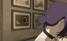 a girl with purple hair is looking at a wall of framed pictures