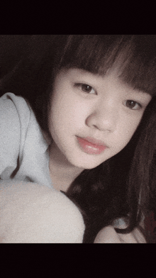 a close up of a girl 's face with a gray shirt on
