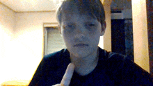 a young boy is giving a thumbs up in front of a window