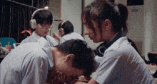 a girl with headphones on looks down at a man 's head