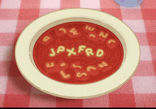 a bowl of soup with the letters jpxfrd written in it