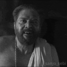 a black and white photo of a man with a beard and the name sanjo_sebi on the bottom
