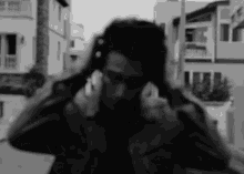 a man covering his ears with his hands in a black and white photo