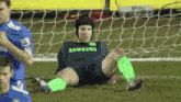 a soccer player wearing a samsung jersey lays on the field