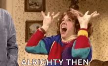 a woman in a colorful sweater is screaming with her hands in the air .