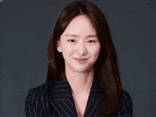 a woman is wearing a striped jacket and smiling for the camera