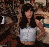 a woman wearing headphones and a crop top that says ' ohhh ' on it