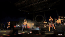 a group of women singing on a stage with a rbd.gif watermark