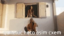a man and a woman are sitting in front of a window with the words quneluc hetoasim cxem written below them