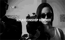 a black and white photo of a woman holding a gun with the words relationship reboot written below her