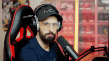 a man wearing headphones and glasses is sitting in a dxr racer chair