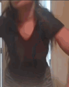 a woman in a black shirt is dancing in front of a door .