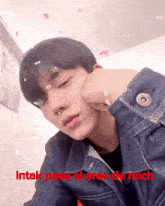 a young man in a denim jacket with the words " intak posa si eres de mich " written below him