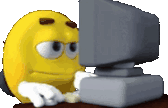 a yellow smiley face is sitting in front of a computer monitor