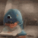a blue dolphin toy is sitting on a table with a book .
