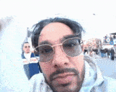 a man with a beard wearing glasses and a reebok jacket