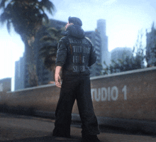 a man is standing in front of a wall with studio 1 written on it