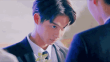 a man in a suit and tie is looking at another man in a suit and tie .