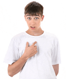 a young man in a white t-shirt is pointing to his chest