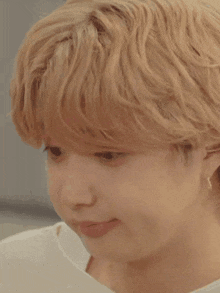 a close up of a person 's face with short blonde hair