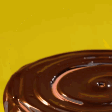 a chocolate covered donut is being dipped into chocolate sauce
