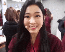 a close up of a woman wearing a red jacket and smiling .
