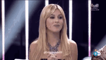 a blonde woman is sitting in front of a microphone on a tv show called talent