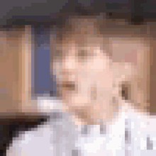 a blurry picture of a man in a white suit and bow tie with blue tears coming out of his eyes .