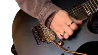 a person with a ring on their finger playing a guitar