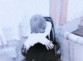 a person in a white shirt is sitting in a chair