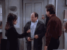 two men and a woman are standing in front of a door that says ' a ' on it