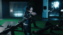 a man in a black leather jacket is pointing at something in the dark