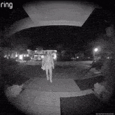 a ring doorbell shows a man walking in front of a house at night