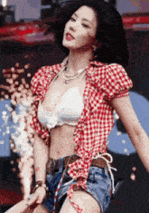 a woman in a plaid shirt and shorts is dancing on stage