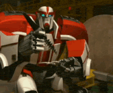 a red and white robot with blue eyes is holding something in his hand