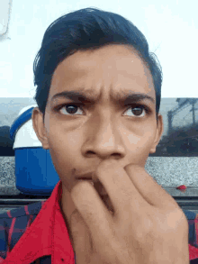 a close up of a person 's face with their hand in their mouth