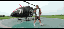 a man is standing in front of a helicopter with the number 7 on it