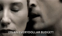 a man is whispering into a woman 's ear while kissing her on the cheek .