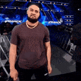a man with a beard is standing in front of a stage that says smack down