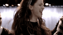 a woman wearing a headband and a black shirt is laughing