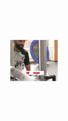 a man with a beard is standing in front of a machine that says push