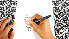 a person drawing on a piece of paper with a black marker that says ' snoopy ' on it