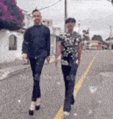 a man and a woman are walking down a street with the words mr. & mrs. n studio written on the bottom