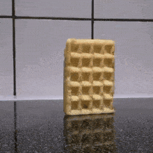 a waffle is sitting on a counter in front of a white tiled wall