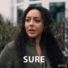 a woman in a green jacket with the word sure written on it