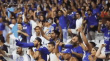 a crowd of people are sitting in a stadium cheering for their team .