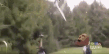 a person with a mask on their head is standing in a field .