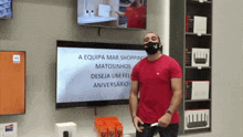 a man wearing a mask stands in front of a screen that says a equipa mar shopping