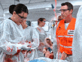 a man wearing an orange primary emergency vest