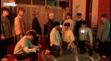 a group of young men are posing for a picture in a room with a brick wall .